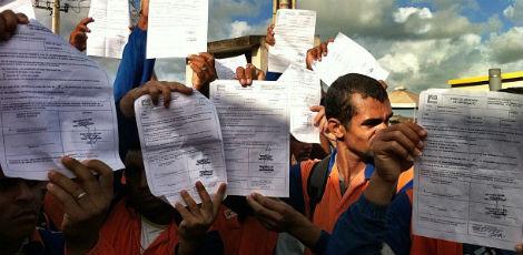 Trabalhadores mostram a carta de demissão entregue pelo Consórcio Ipojuca / Foto: Adriana Guarda/JC