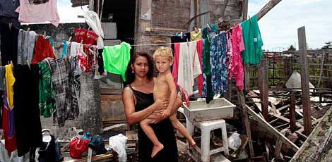 Cícera da Silva, com o filho Jairo, na casa de tábua onde vive há cinco anos, nos Coelhos / Foto: Bobby Fabisak/JC Imagem