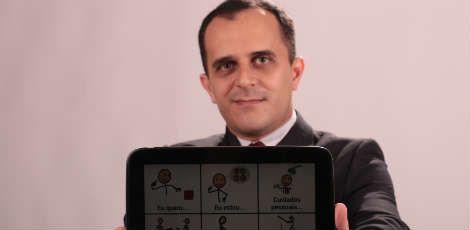 Carlos Edmar exibe, no tablet, o aplicativo que usa para falar com Clara / Divulgação