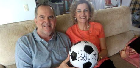 Alberto e a esposa, Catarina, posam com a bola autografada pelo astro britânico / Foto: arquivo pessoal
