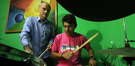 Paulo Barreto (em pé) usa a música para ajudar pacientes como Fábio Silva, de 17 anos  / Diego Nigro/JC Imagem