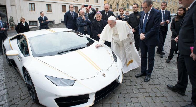 O pontífice benzeu o carro e assinou o capô, diante de diretores da marca presentes no Vaticano / Foto: Handout / OSSERVATORE ROMANO / AFP